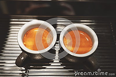 Two cups of fresh made hot coffee espresso americano standing on professional coffee machine Stock Photo