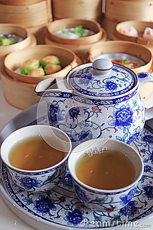 Two Cups of Hot Chinese Oolong Tea with Assorted Dim Sum Dishes in Background Stock Photo