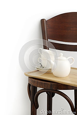 Two cups and pot on brown chair Stock Photo