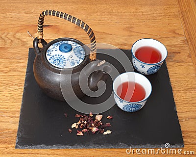 Two cups of Rosehip Tisane with teapot and leaves Stock Photo
