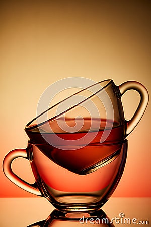 Two cups and saucers of glass. Tea is poured into the top Cup. Helium filter gives a beautiful light Stock Photo
