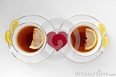 Two cups of tea with lemon and red heart on white background. The concept of relationship, happy couple in love Stock Photo