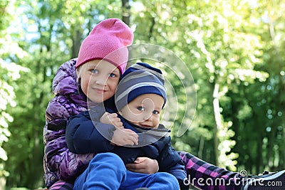 Two cute adorable playful caucasian siblings boy girl child enjoy havefun on playground at backyard or city park Stock Photo