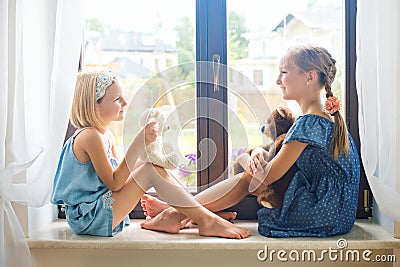 Two cute european toddler girls playing near window at home Stock Photo