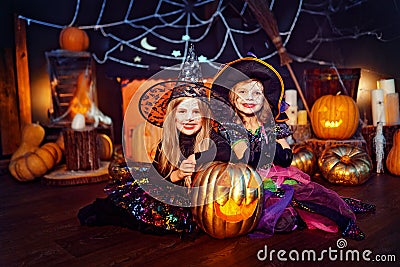 Two cute funny sisters celebrate the holiday. Jolly children in carnival costumes ready for Halloween. Stock Photo