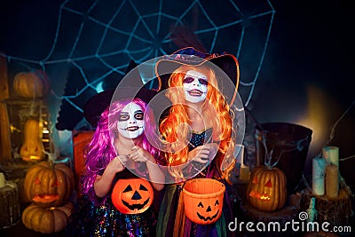 Two cute funny sisters celebrate the holiday. Jolly children in carnival costumes ready for Halloween. Stock Photo