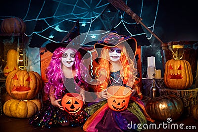 Two cute funny sisters celebrate the holiday. Jolly children in carnival costumes ready for Halloween. Stock Photo