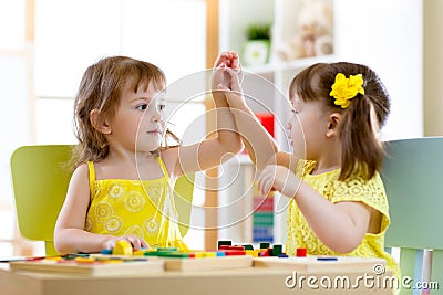 Two cute little girls playing together in daycare Stock Photo