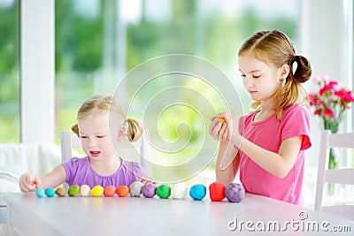 Two cute little sisters having fun together with colorful modeling clay at a daycare Stock Photo