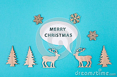 Two cute reindeers talking to each other, speech bubble with merrychristmas greetings, blue colored background Stock Photo