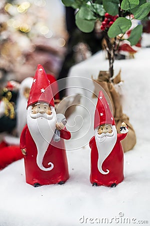 two cute Santa Clauses in red caps with gifts in the snow. Stock Photo