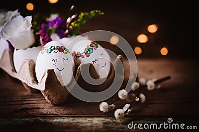 Two cute sleeping Eastereggs in a paper egg box on dark wooden background Stock Photo