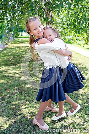 Two cute smilling little girls posing in front of their school. Stock Photo