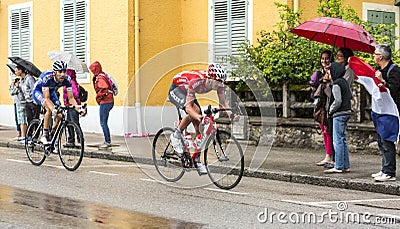 Two Cyclists Riding in the Rain Editorial Stock Photo