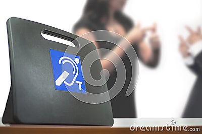 Two deaf people using American Sign Language next to a Tele Coil Magnetic Loop with T-switch with induction system for hearing aid Stock Photo