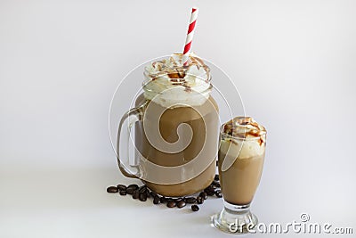 Two Delicious iced coffee or Frappuccino with whipped cream , syrup and a red straw . With Coffee beans isolated on white Stock Photo
