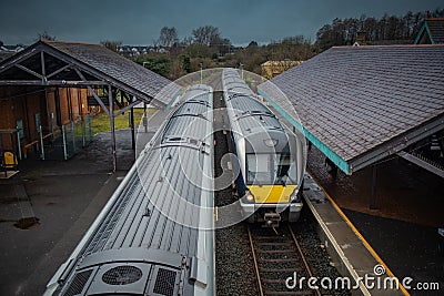 Two diesel trains are crossing at ballymoney train station in northern ireland. Looking towards the trains and train tracks from Stock Photo