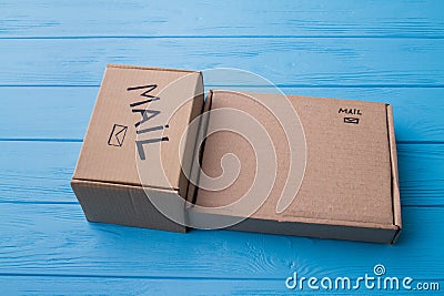 Two different cardboard boxes on blue wood. Stock Photo