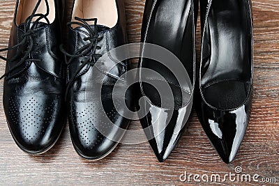 Two different Pairs of black classic modern shoes on the wooden floor background Stock Photo