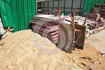 Two dirty wheelbarrows,sand and construction equipment at Construction site. Stock Photo