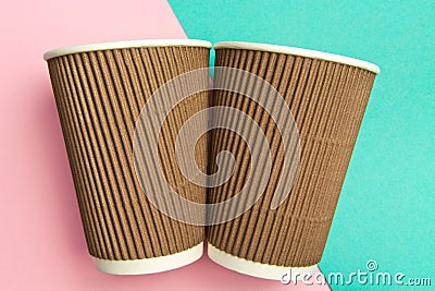 Two disposable cups for hot drinks on a geometric pink and turquoise backgrounds. Paper cups Stock Photo