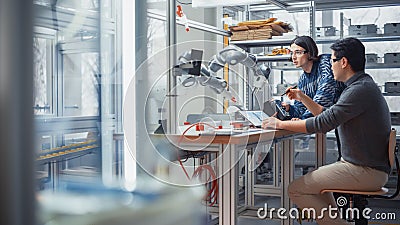 Two Diverse Developers Brainstorming and Coding on Laptop. Caucasian Male Press Button on Control Stock Photo