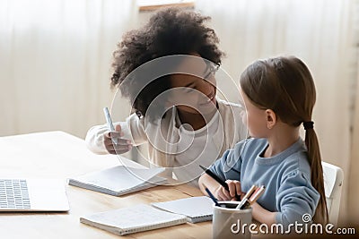 Two diverse little girls doing school tasks, homework together Stock Photo