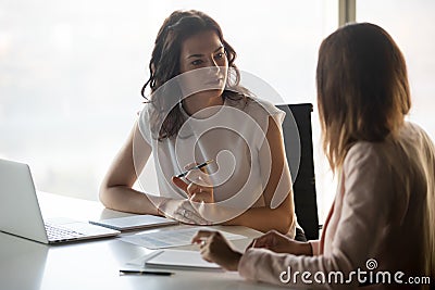 Two diverse serious businesswomen talking working together in office Stock Photo