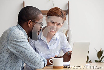 Two diverse smiling businesspeople discussing online project Stock Photo