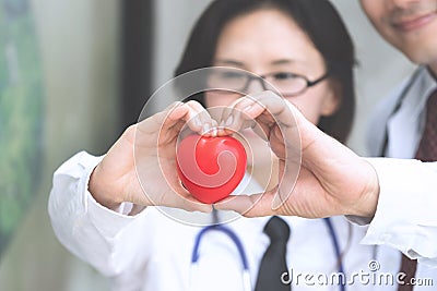 Two docter holding a red heart, health care concept. Stock Photo