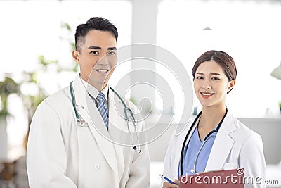 Two doctors smiling and standing in Hospital Stock Photo