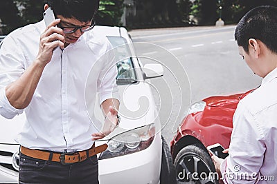 Two drivers man arguing after a car traffic accident collision and making phone call to Insurance Agent, Traffic Accident and Stock Photo