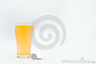 Two effervescent tables with glass of orange flavored medicine Stock Photo