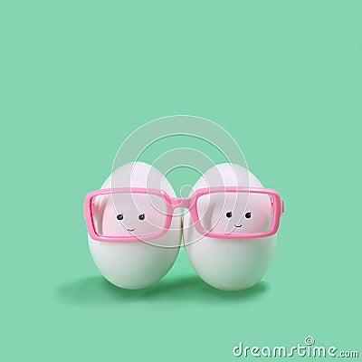 Two eggs in pink glasses like Siamese twins Stock Photo