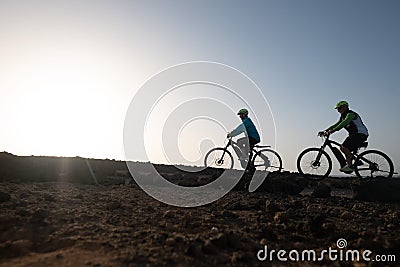 Two elderly athletes man and woman bicycling along the cliff. Freedom and healthy lifestyles Stock Photo