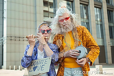 Two elderly hippy men encouraging people for donating love Stock Photo