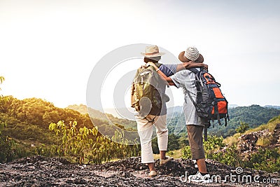 Two elderly women hiking backpacking And standing on a high mountain Happy retirement. Stock Photo