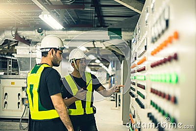 Two Electrical Engineer team working front control panel. Stock Photo