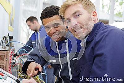Two electrician workers at wiring cable and light switch Stock Photo