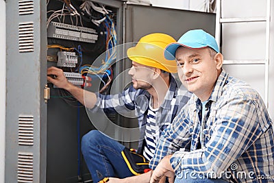 Two electricians near distribution board indoors Stock Photo