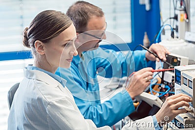 Two electronic engineers on the test bench measuring a new product Stock Photo