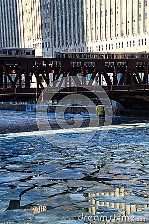 Two elevated `el` trains cross Chicago River during morning rush hour on a frigid, winter morning in Chicago. Stock Photo