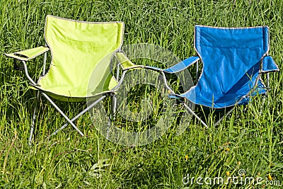 Two empty folding chair on the green grass Stock Photo