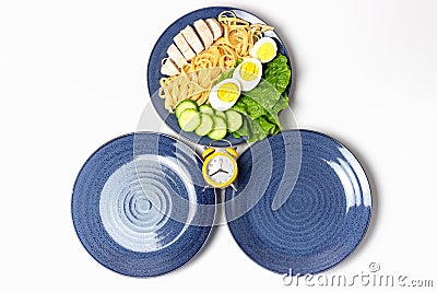 Two empty plates and one plate of food, concept of intermittent fasting. Stock Photo