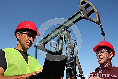 Two Engineers With Laptop Computers in the Oil Field Stock Photo