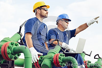 Two engineers working inside oil and gas refinery Stock Photo