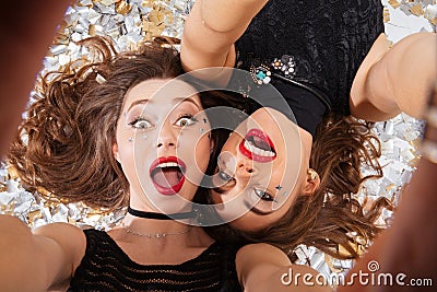 Two excited pretty women taking selfie and lying Stock Photo