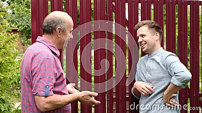 two farmers takling to each other on sunny day. They discuss important news Stock Photo