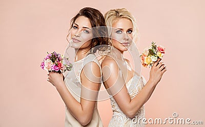 Two Fashion Models with Flowers Bouquet Beauty Portrait, Beautiful Women Studio Shot with Rose Flower in Hair Stock Photo