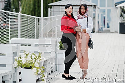 Two fashionable arabian girls friends posed outdoor. Stylish muslim womans Stock Photo